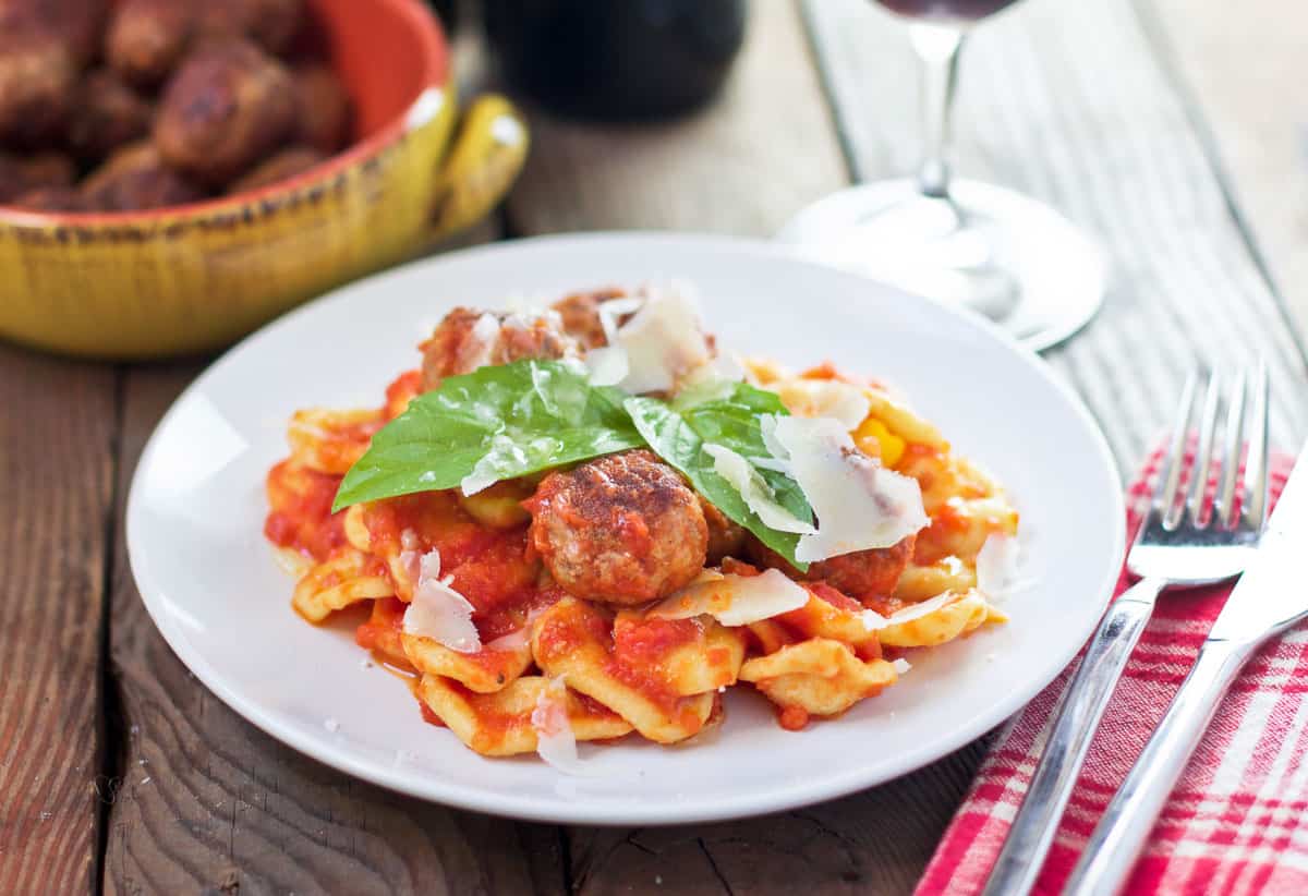 A bowl of orecchiette pasta topped with meatballs