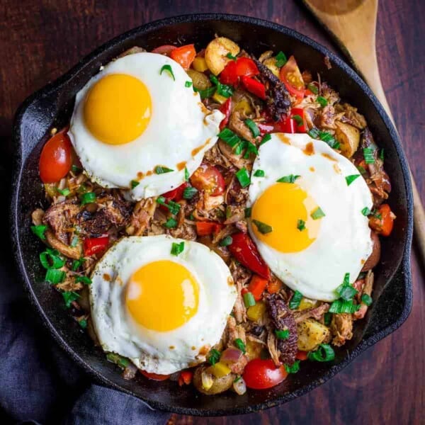 Pulled pork breakfast hash in a cast iron pan.