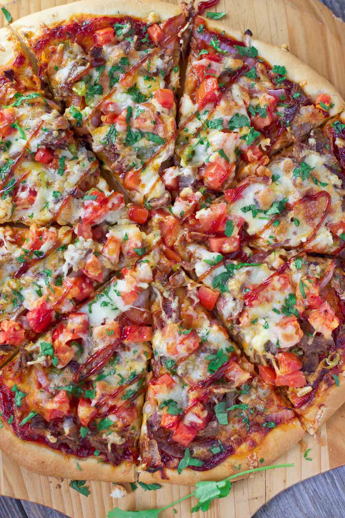 Sliced brisket pizza on a cutting board.