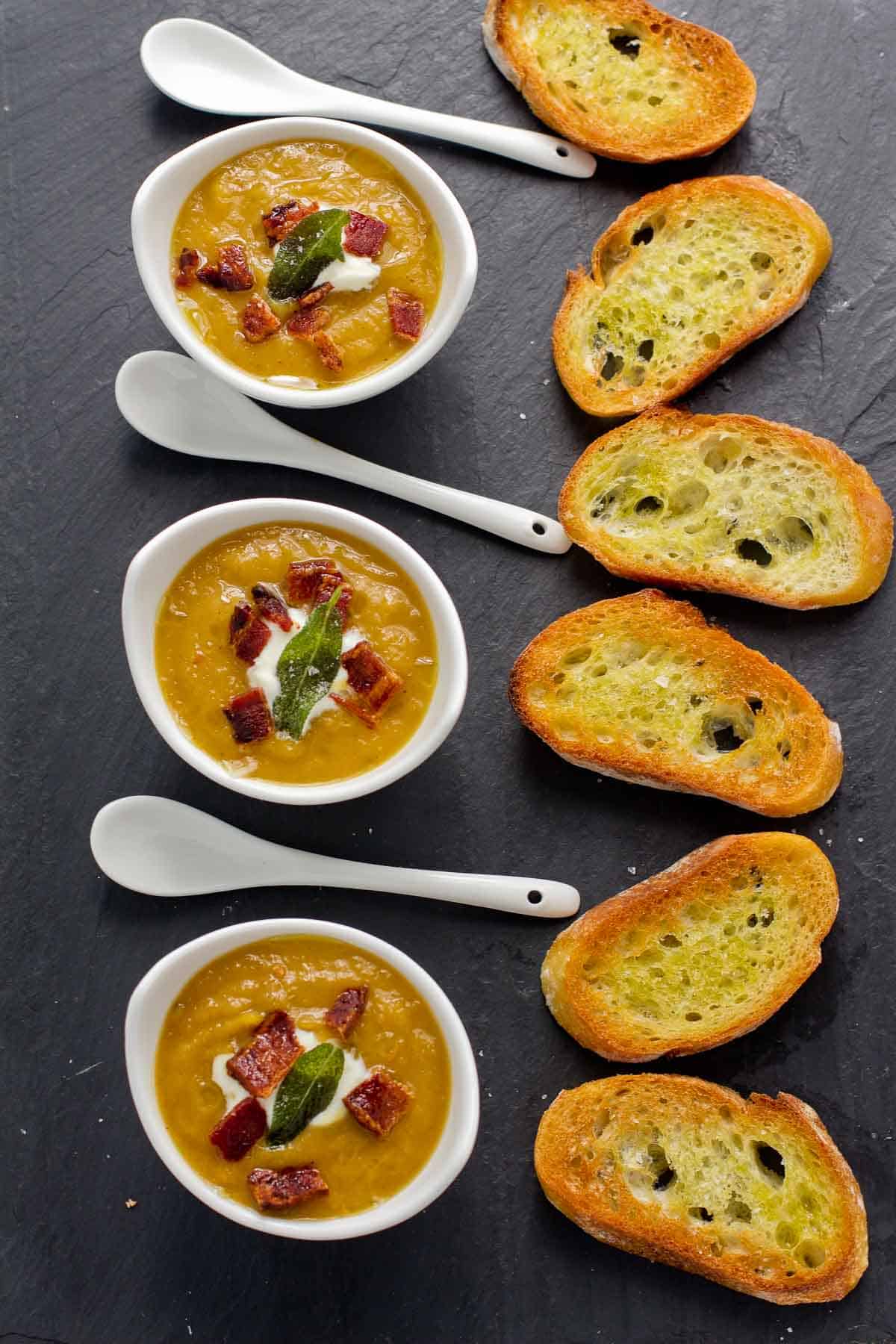 Smoked Butternut Squash Soup in serving bowls with toasted baguette bread