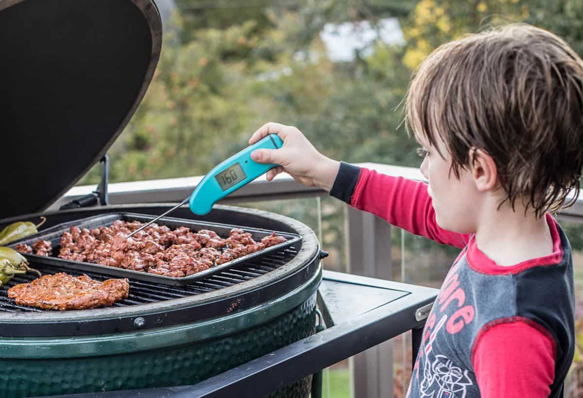 Testing temperature of smoked sausage using a digital thermometer