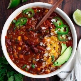 Vegetarian Chili in a bowl with cheese and a spoon.