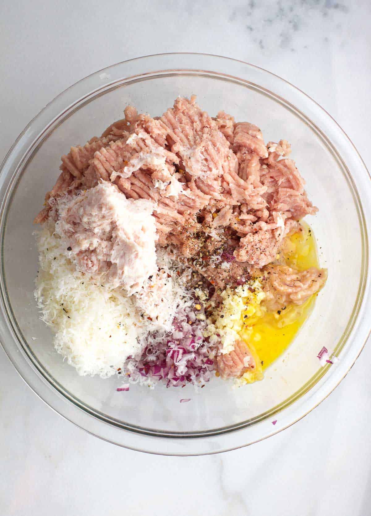 Ingredients for smoked turkey meatballs in a large bowl.