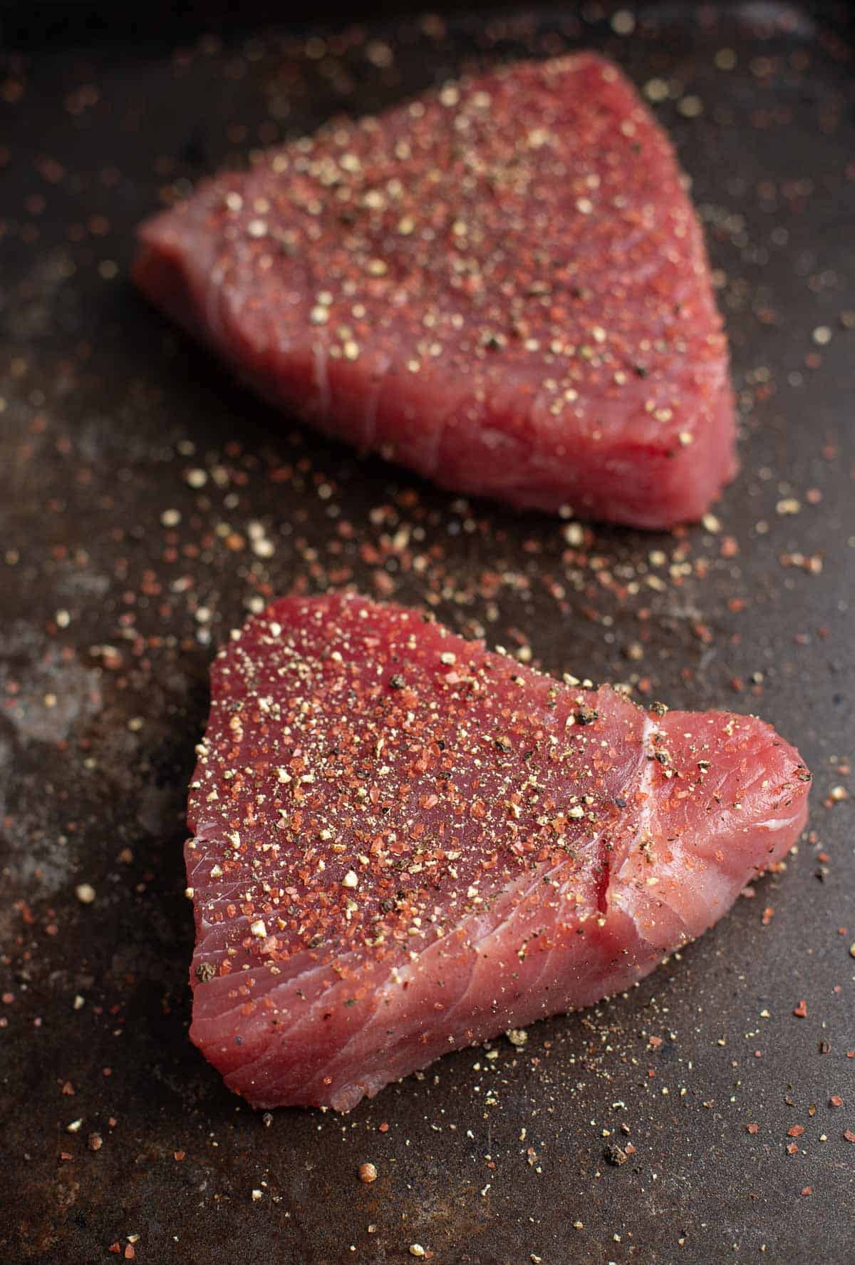 Seasoned raw tuna steaks. Specifically ahi tuna.