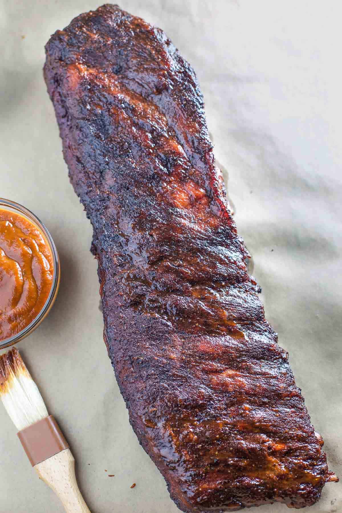 A rack of Smoked Ribs with Low Sugar BBQ Sauce before slicing