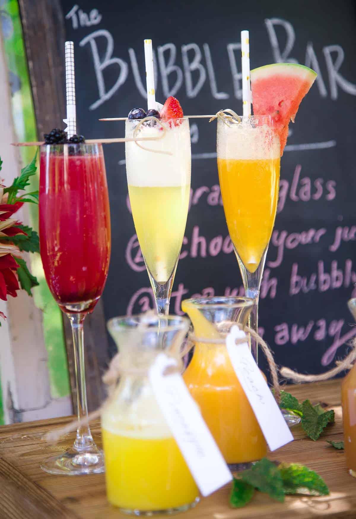 Three glasses with different styles of mimosas set up at a beautiful mimosa bar