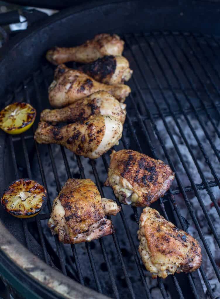 Pieces of chicken grilling over indirect heat.
