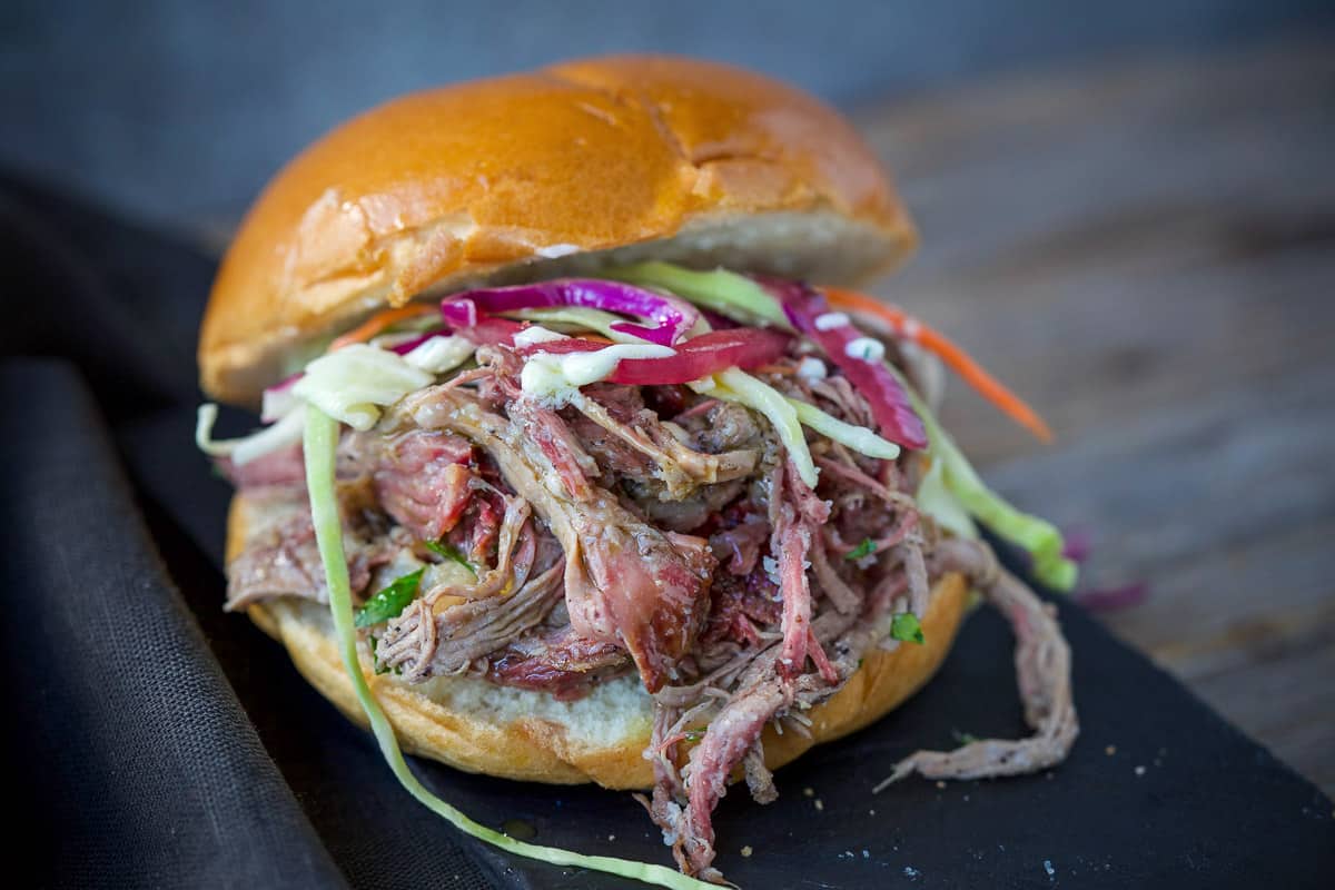 A smoked pulled lamb slider topped with pickled onions and coleslaw