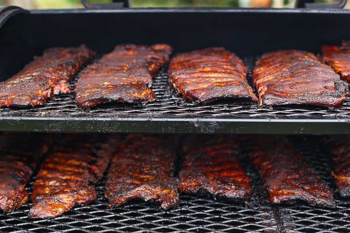 Several racks of ribs cooking on a smoker