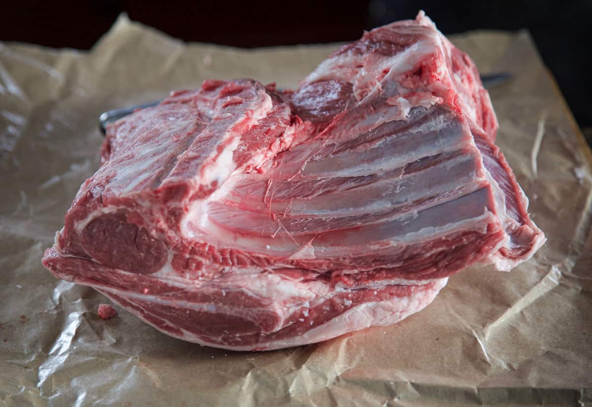 A raw bone-in lamb shoulder on butcher paper