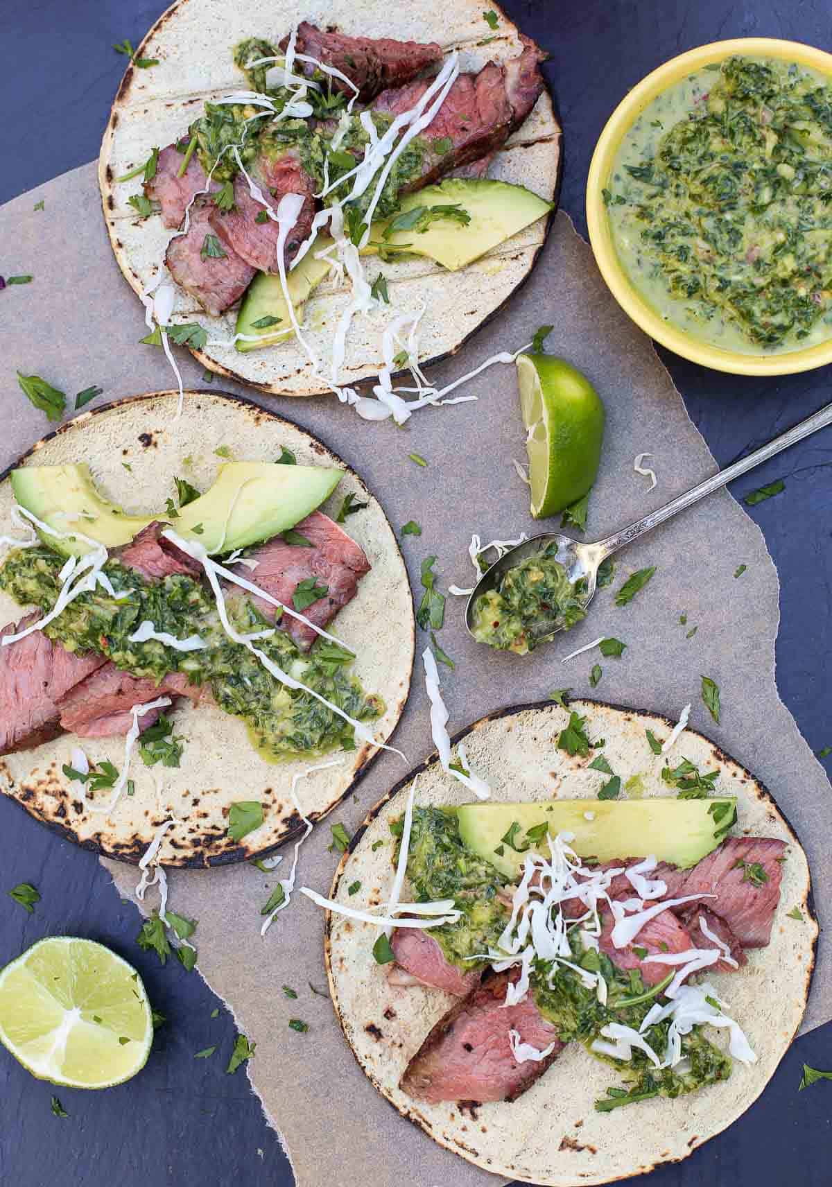 Ribeye Steak Tacos on a platter with chimichurri sauce