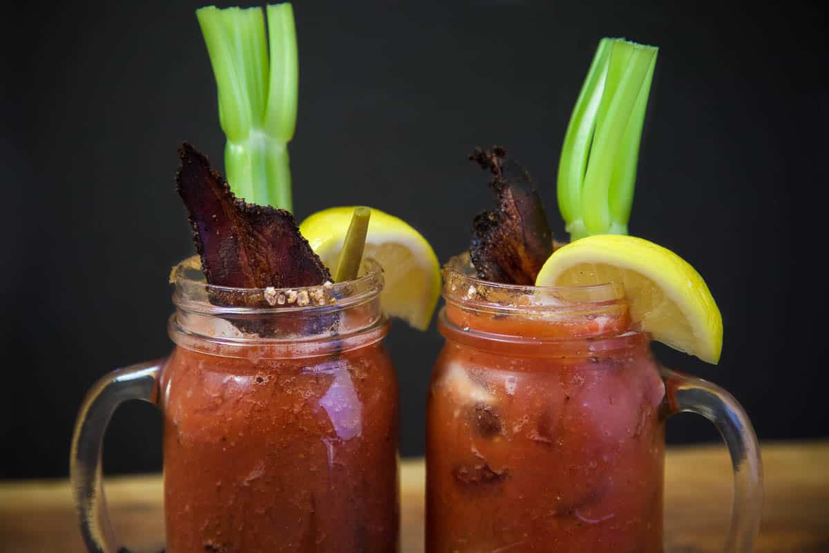 Smoked Bloody Marys garnished with Smoked Bacon, lemon wedge and celery.