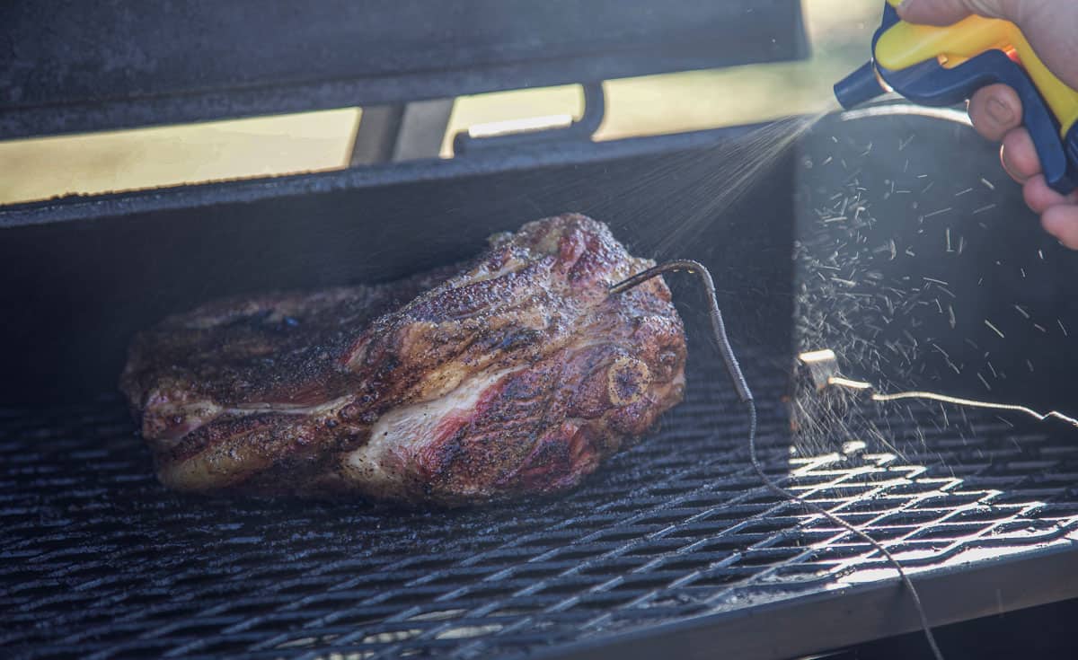 Spritzing a smoked lamb shoulder