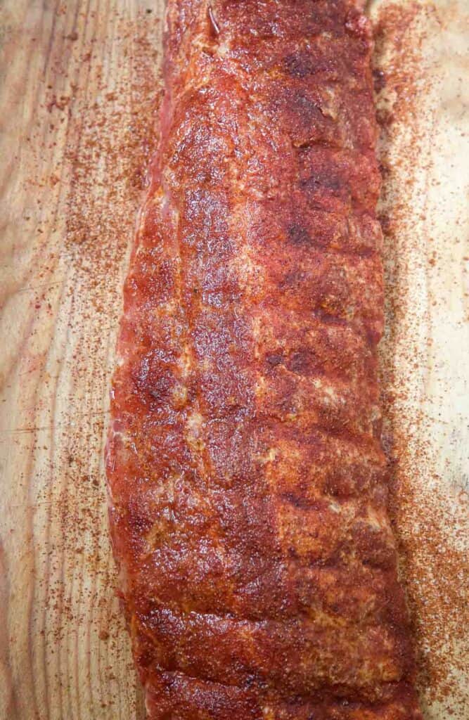 raw baby back ribs seasoned with the ultimate dry rub for ribs