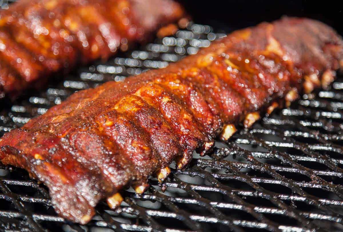 Ribs on the smoker with bones retracting 