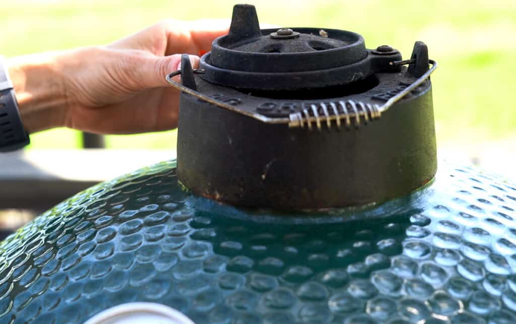 Adjusting top vent of a Big Green Egg.