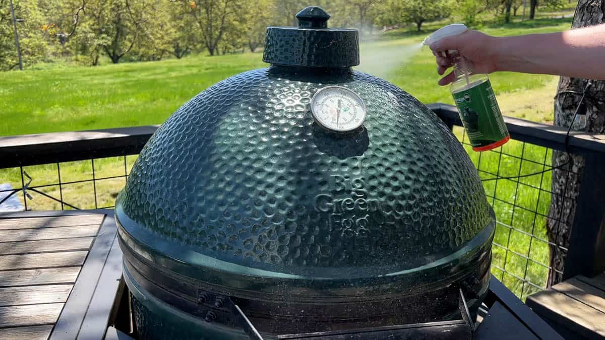 Spraying down the exterior of an XL Big Green Egg using citrus degreaser.