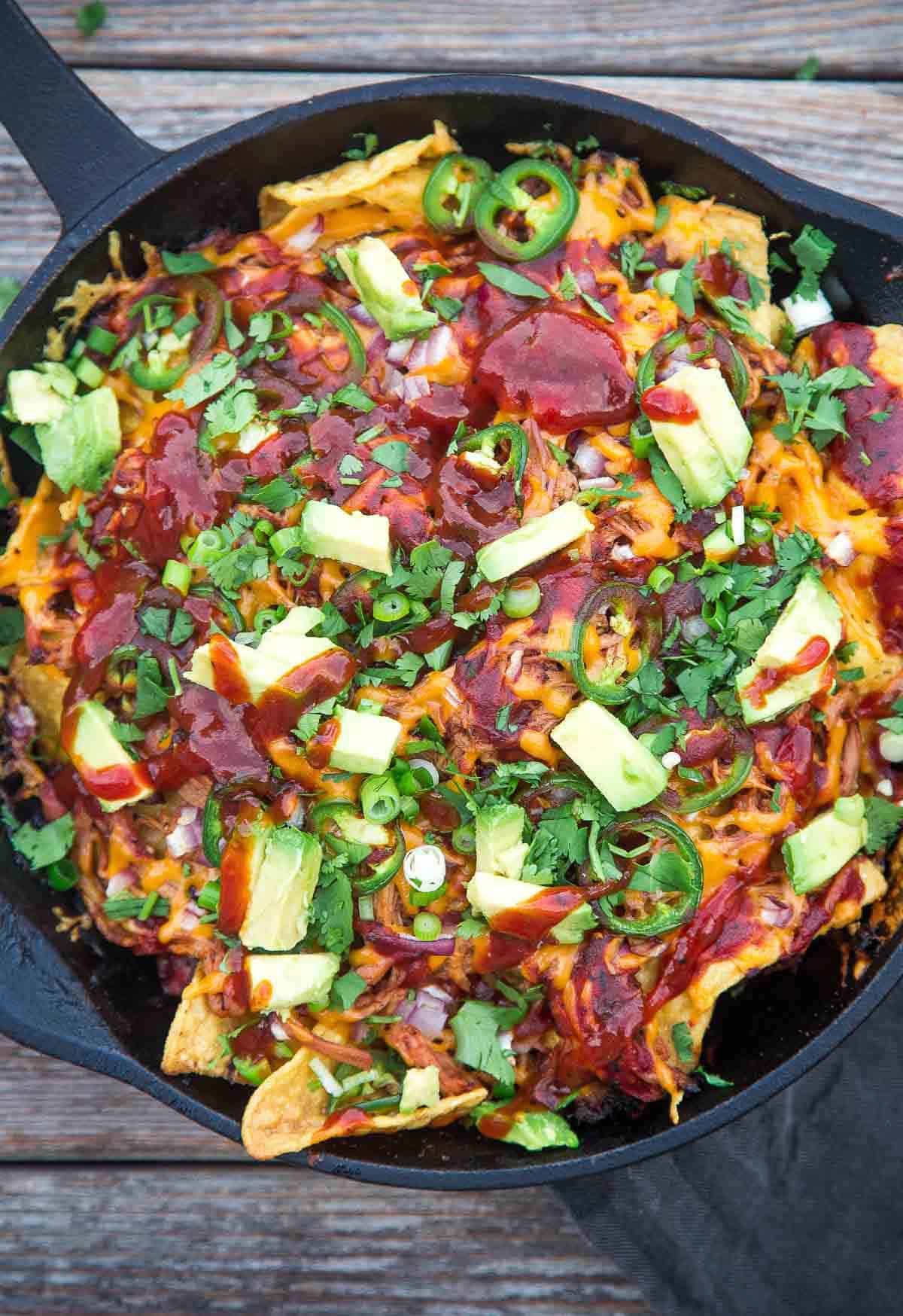 Pulled pork nachos in a cast iron pan.