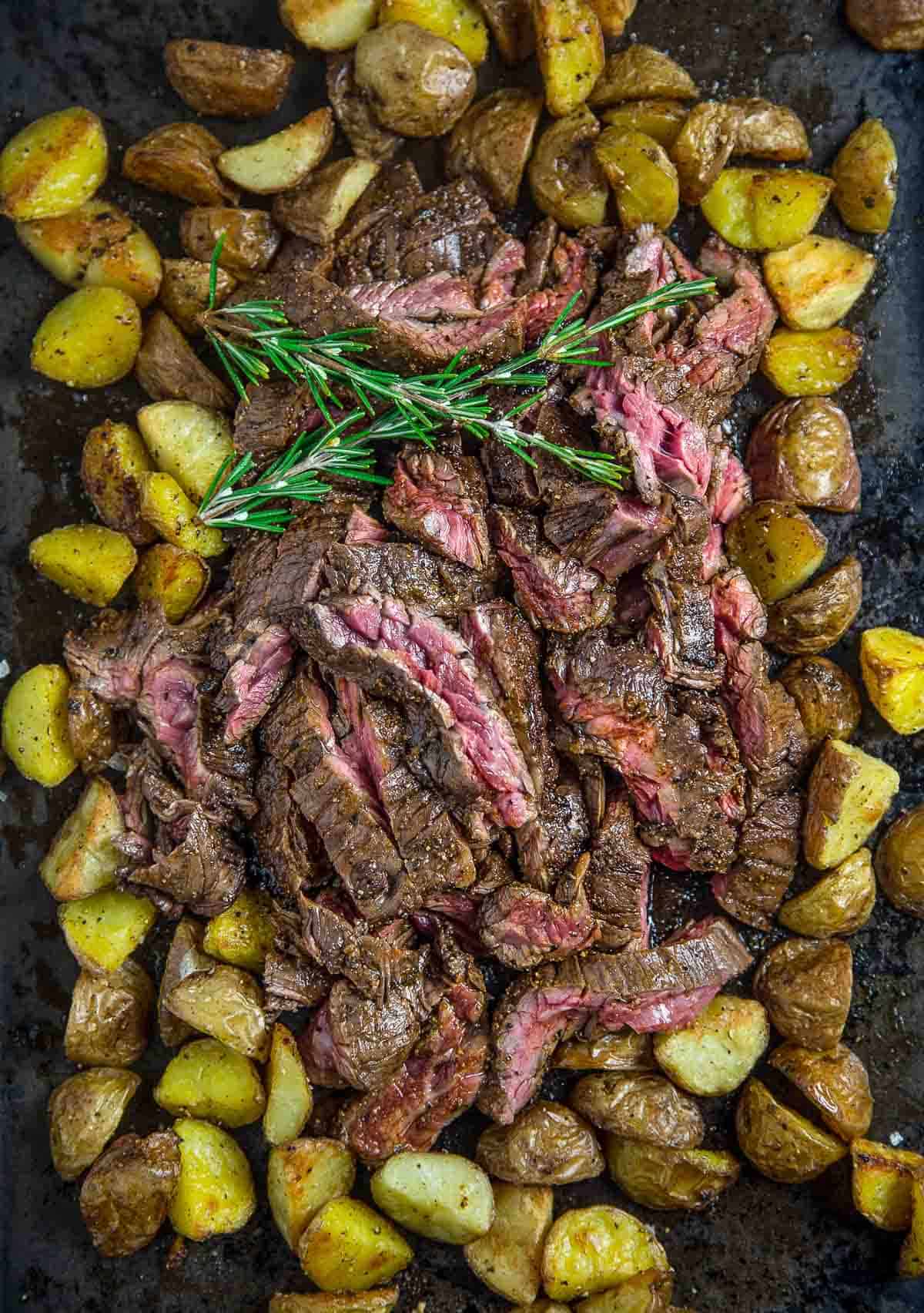 Grilled Skirt steak cooked to medium rare served over roasted potatoes.
