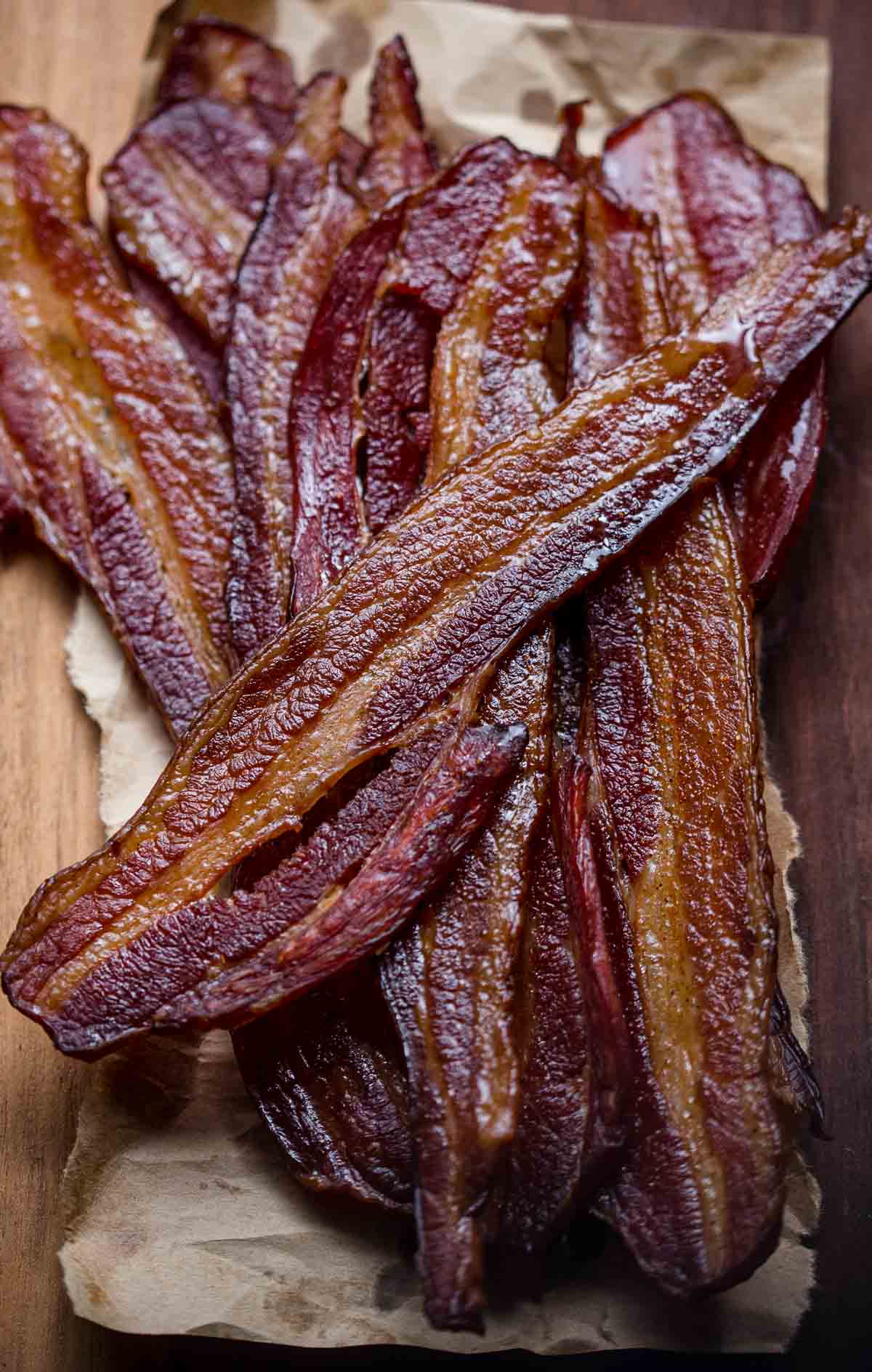 Slices of smoked bacon with a maple cayenne glaze on a cutting board