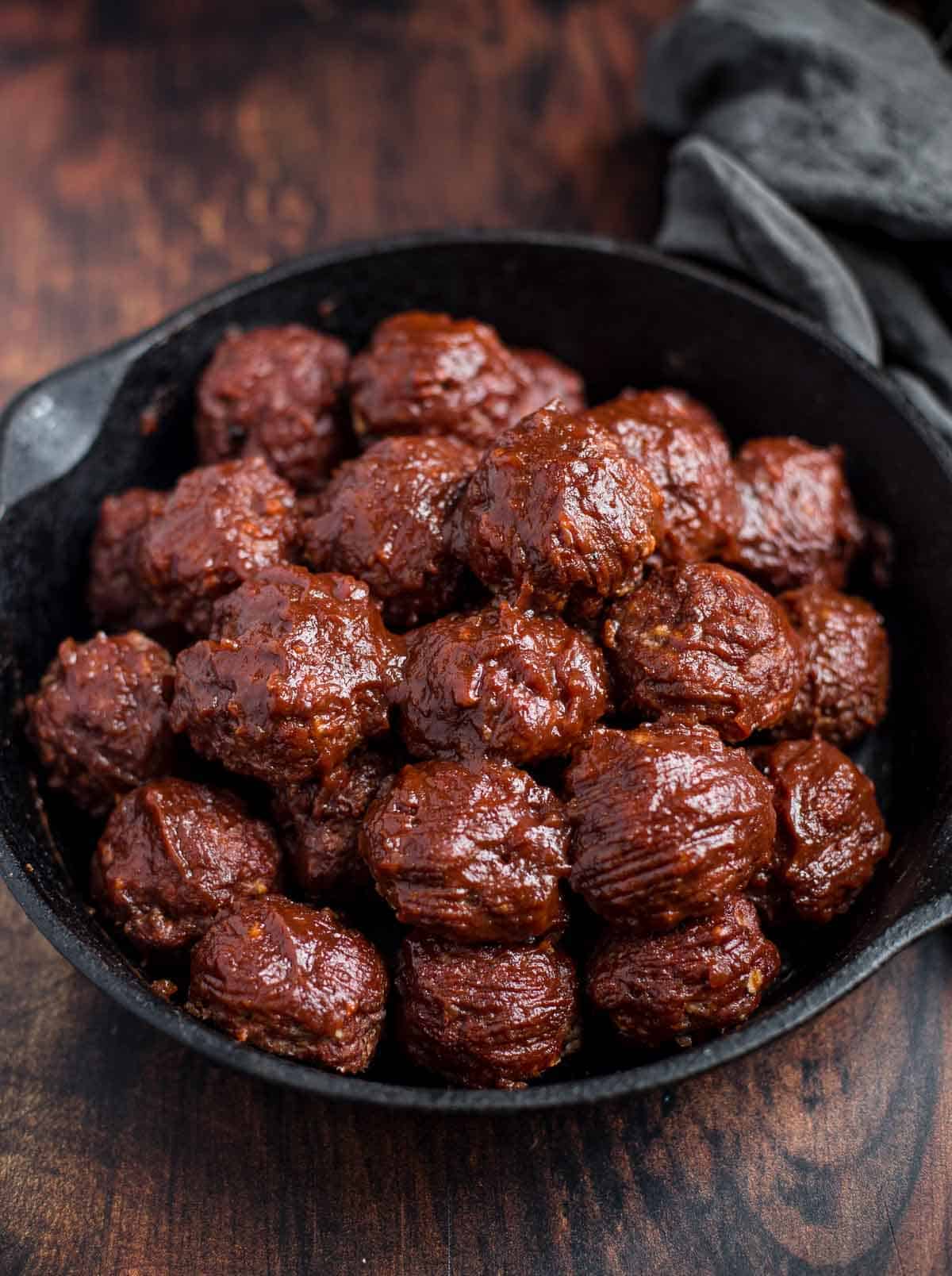 BBQ Meatballs glazed with a Red Wine BBQ Sauce in a cast iron serving dish