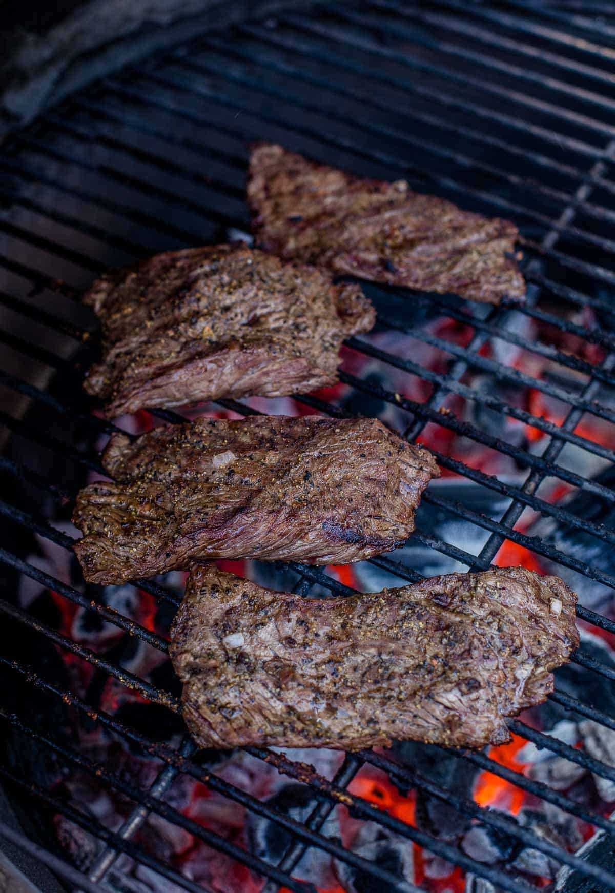 Bavette steak being grilled over direct heat.
