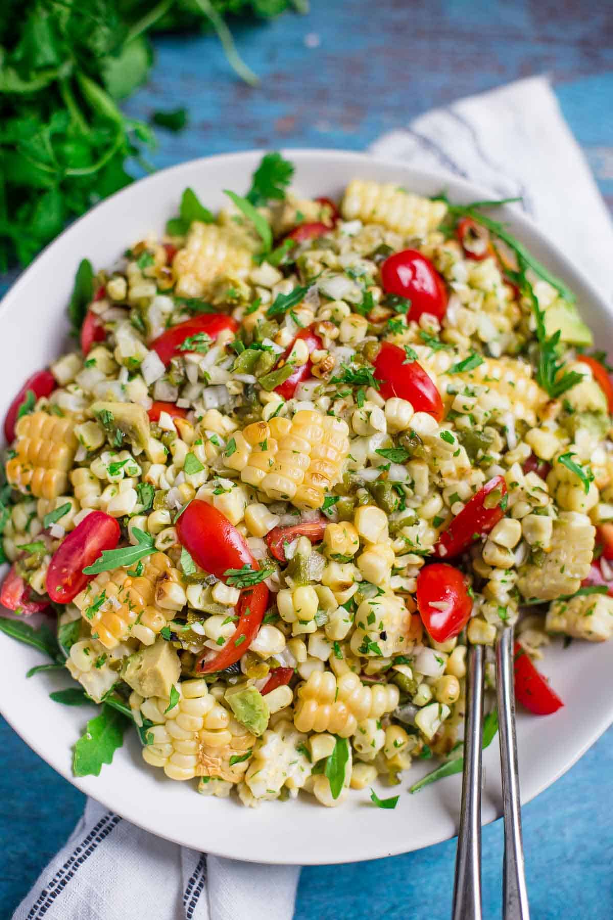 Grilled Corn and Poblano Salad with jalapeños and tomatoes in a serving dish