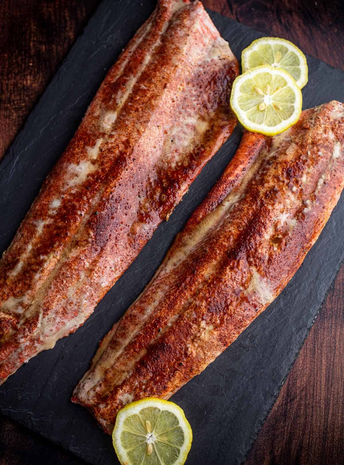 Two Sockeye Salmon filets on a serving dish with slices of lemon