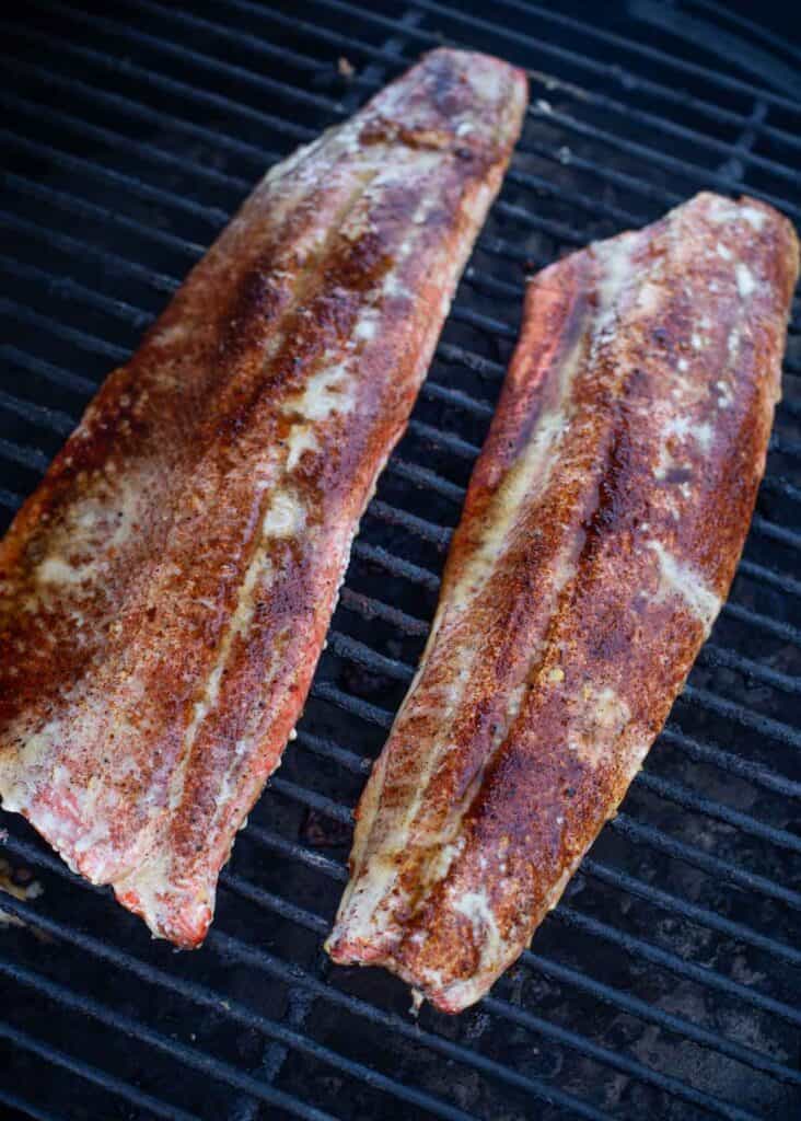 two filets of smoked sockeye salmon on the smoker