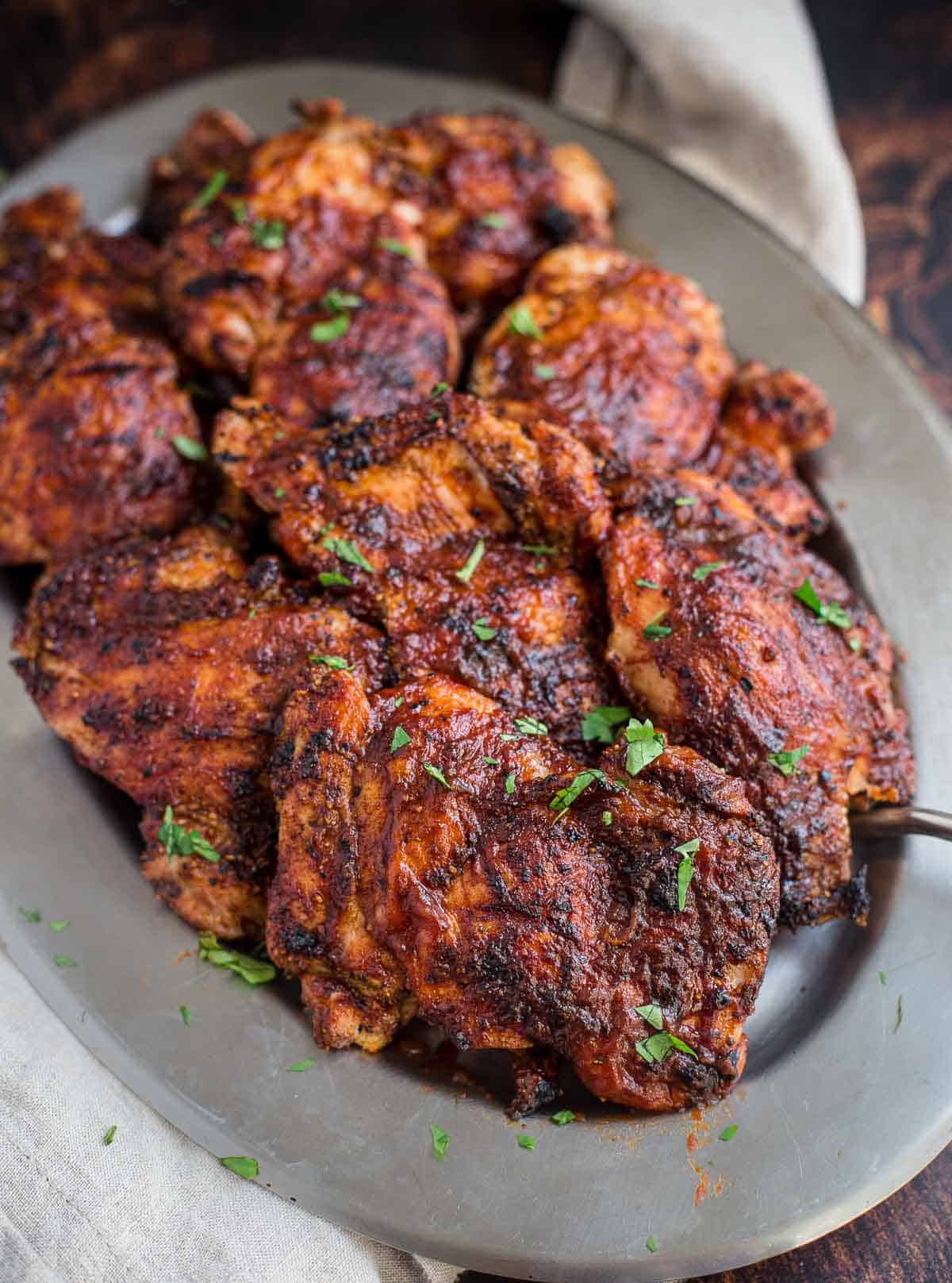 Grilled Boneless Skinless Chicken Thighs on a platter with BBQ Sauce glaze