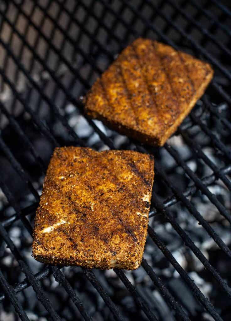 two tofu steaks cooking on the grill