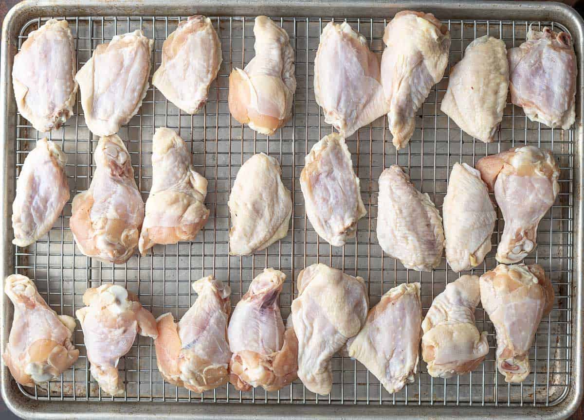 Chicken wing flat and drums on a sheet tray lined with a wire rack.