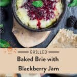 A small cast iron skillet with grilled brie and blackberry jam