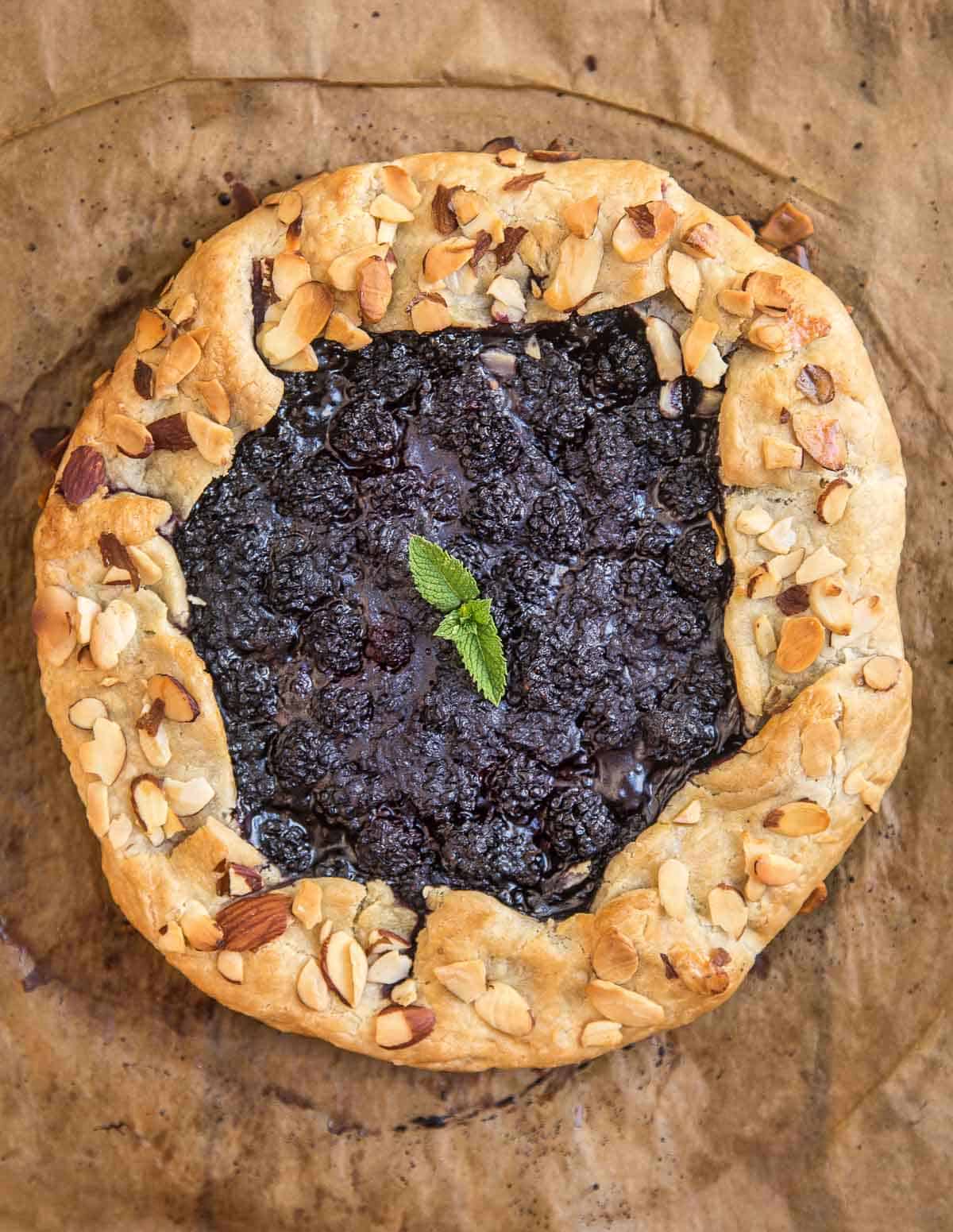 A gluten free blackberry crostata (or galette) on a sheet of parchment paper