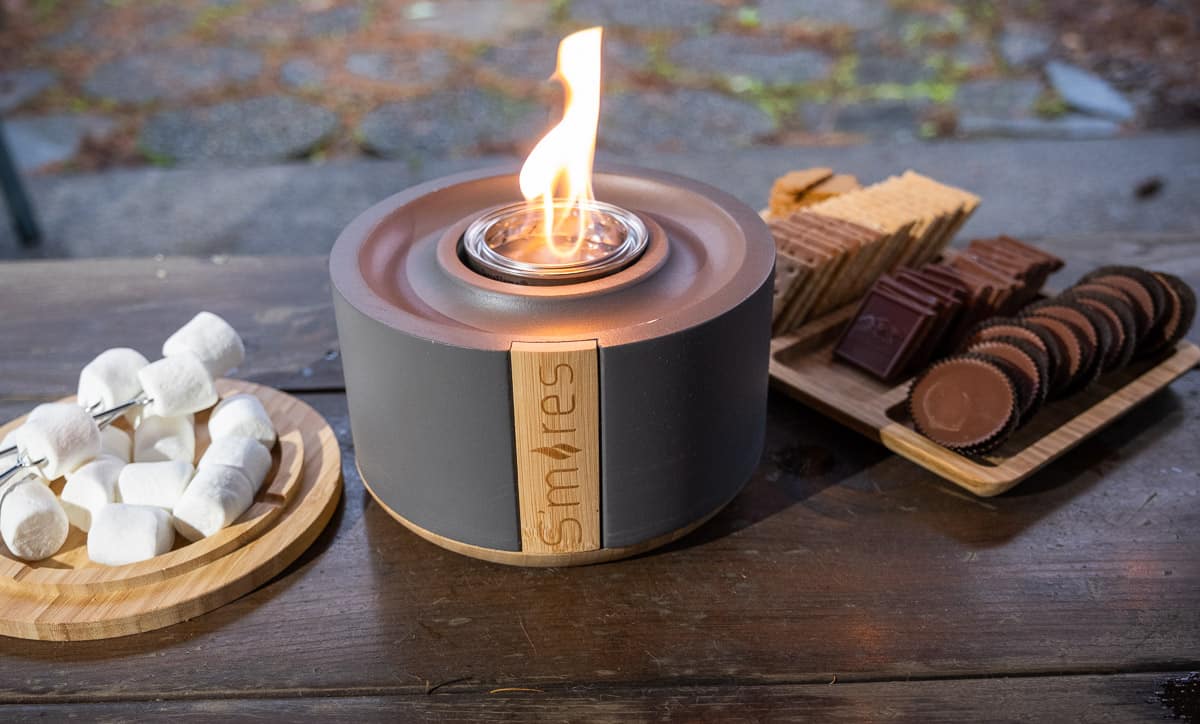 S'mores kit by Solo Stove lit with ingredients and ready for use. Including marshmallows, chocolate, and graham crackers.