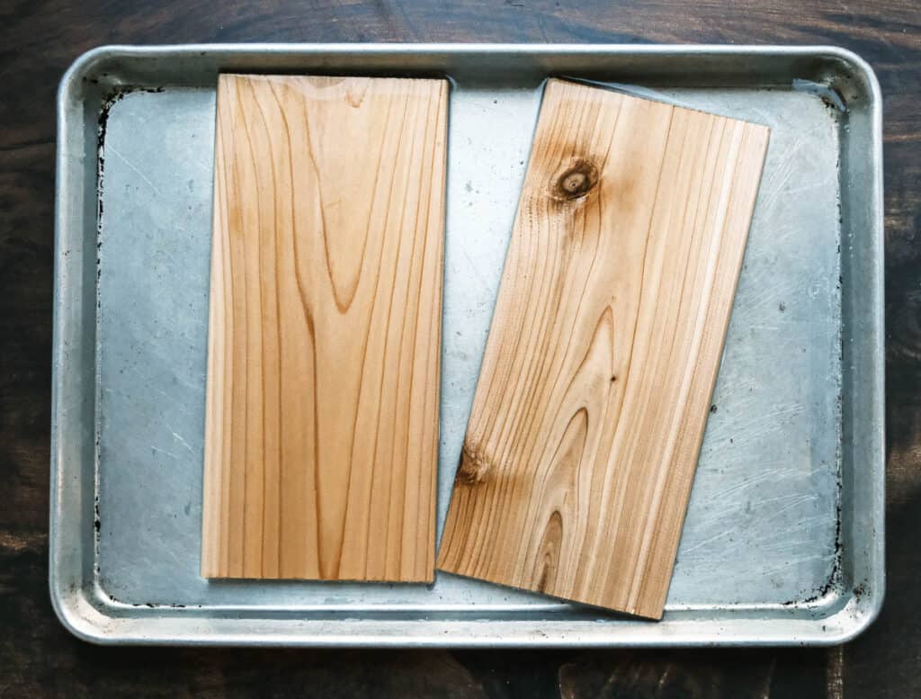 Cedar planks in a sheet tray with water floating.