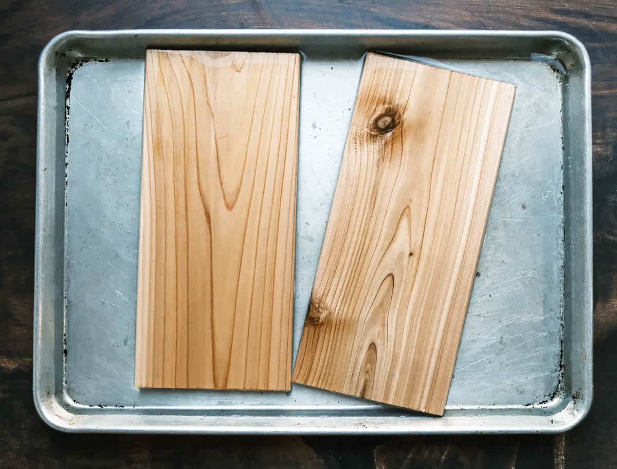Cedar planks soaking in water in a sheet tray.