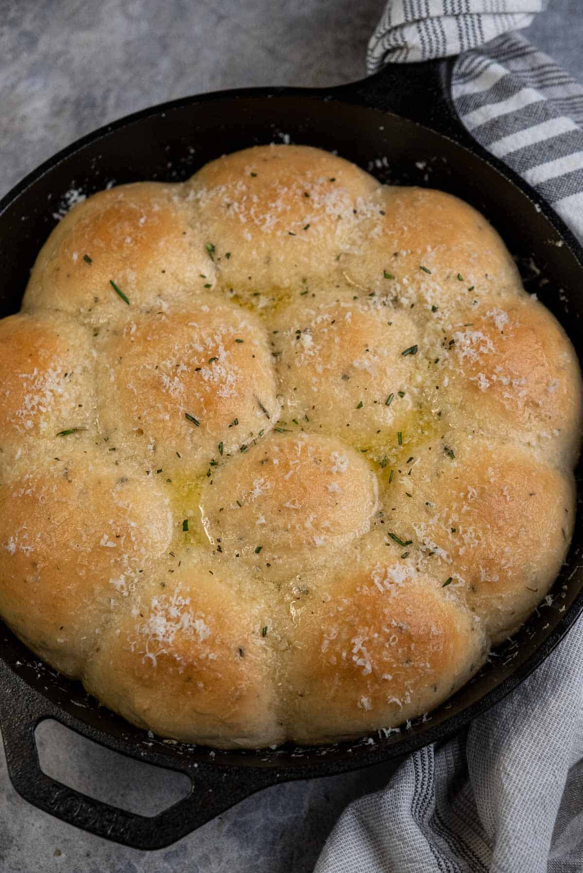 Cast Iron dinner rolls finished with butter and seasonings over the top and ready for serving.
