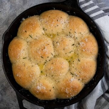 Cast Iron dinner rolls after being grilled and topped with melted butter and seasoning.