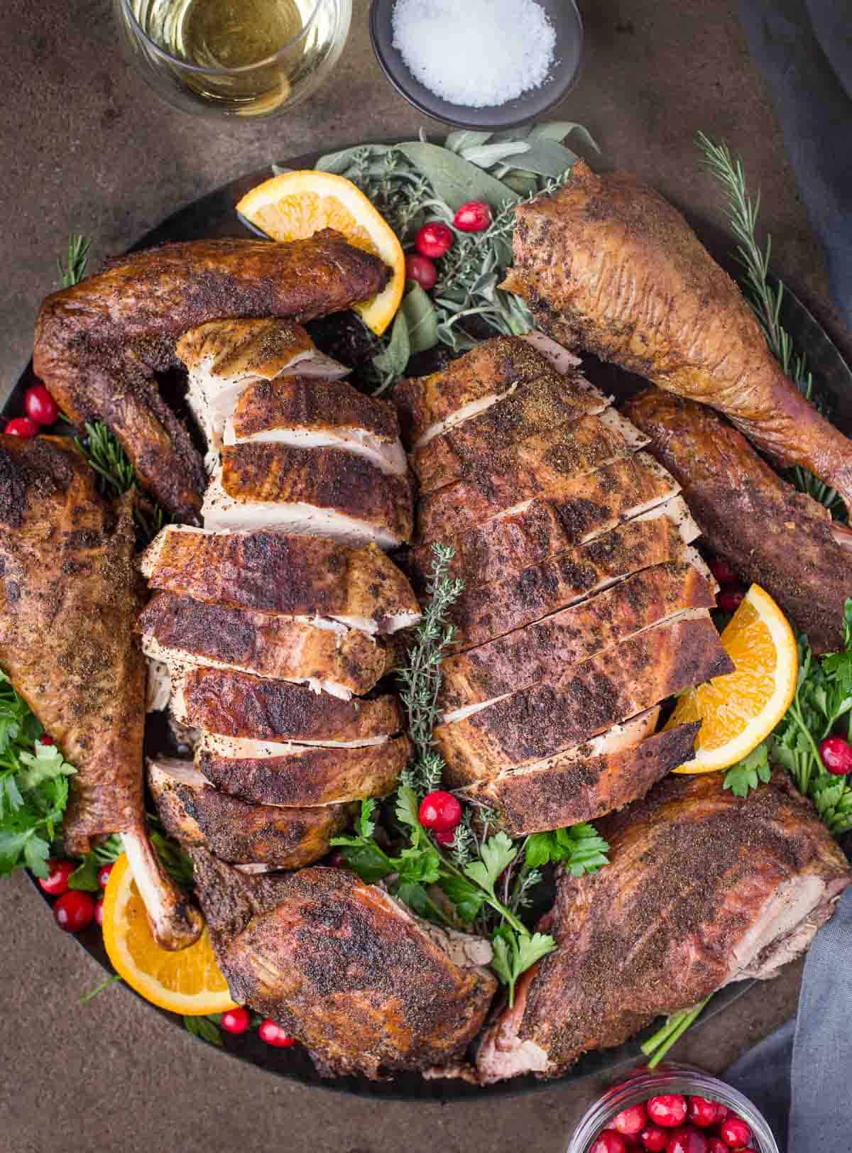 A pellet grilled smoked turkey, sliced up on a serving platter