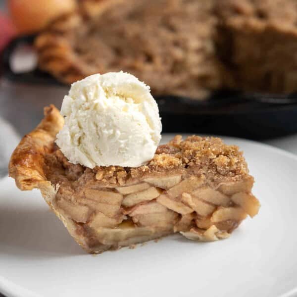 Slice of grilled apple pie topped with vanilla ice cream.