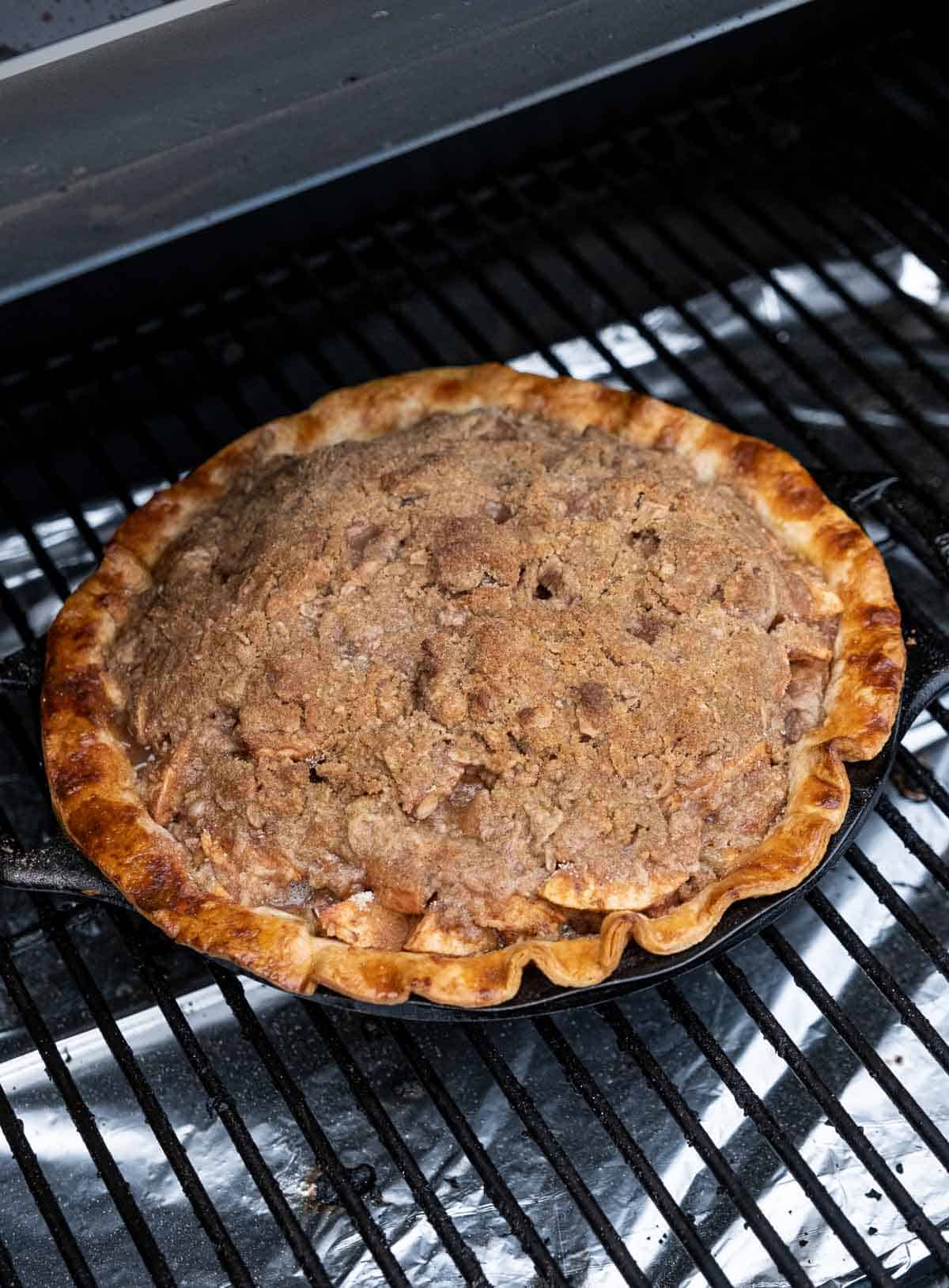 Apple pie on the grill in cast iron pan.