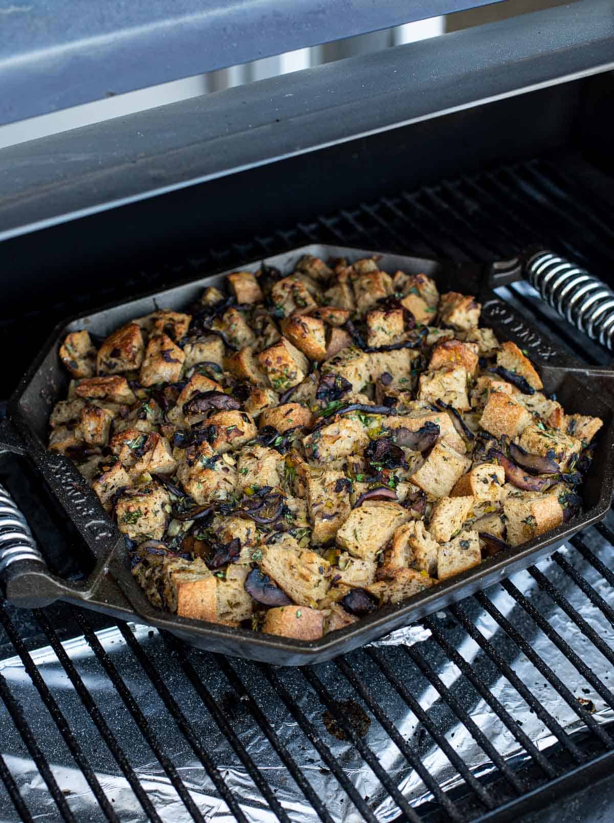 cooking a wild mushroom stuffing in a cast iron skillet on the grill