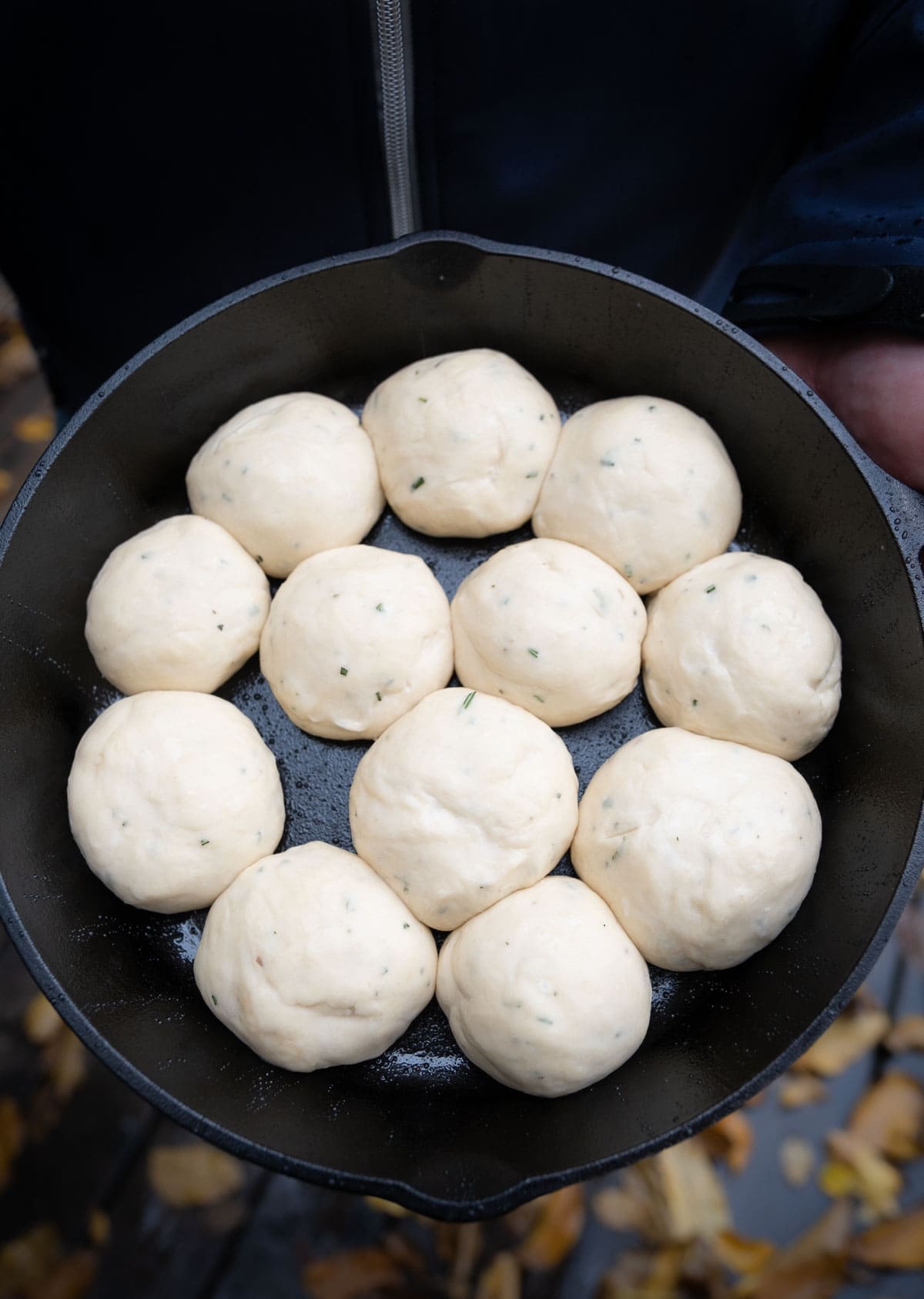 Quick-rise yeast dough balls unbaked in a cast iron pan ready to rise.