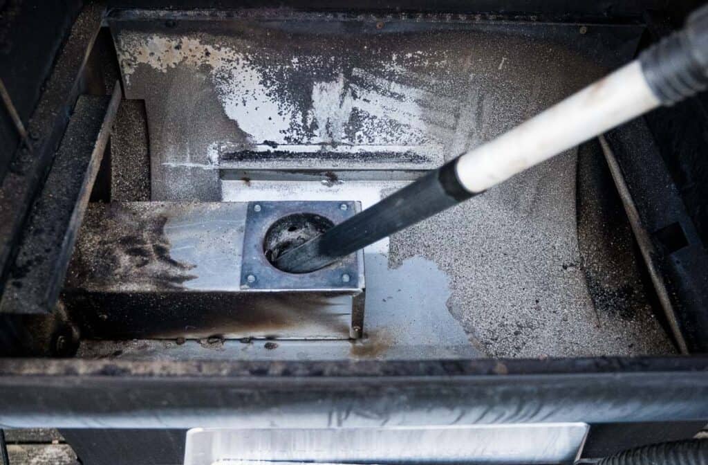 Vacuuming ash from a pellet grill for winterizing.