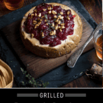 Cedar Plank Brie with Cranberry Sauce on a serving platter topped with toasted hazelnuts