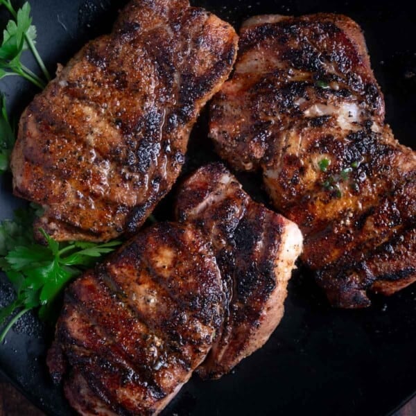 three grilled pork chops on a platter