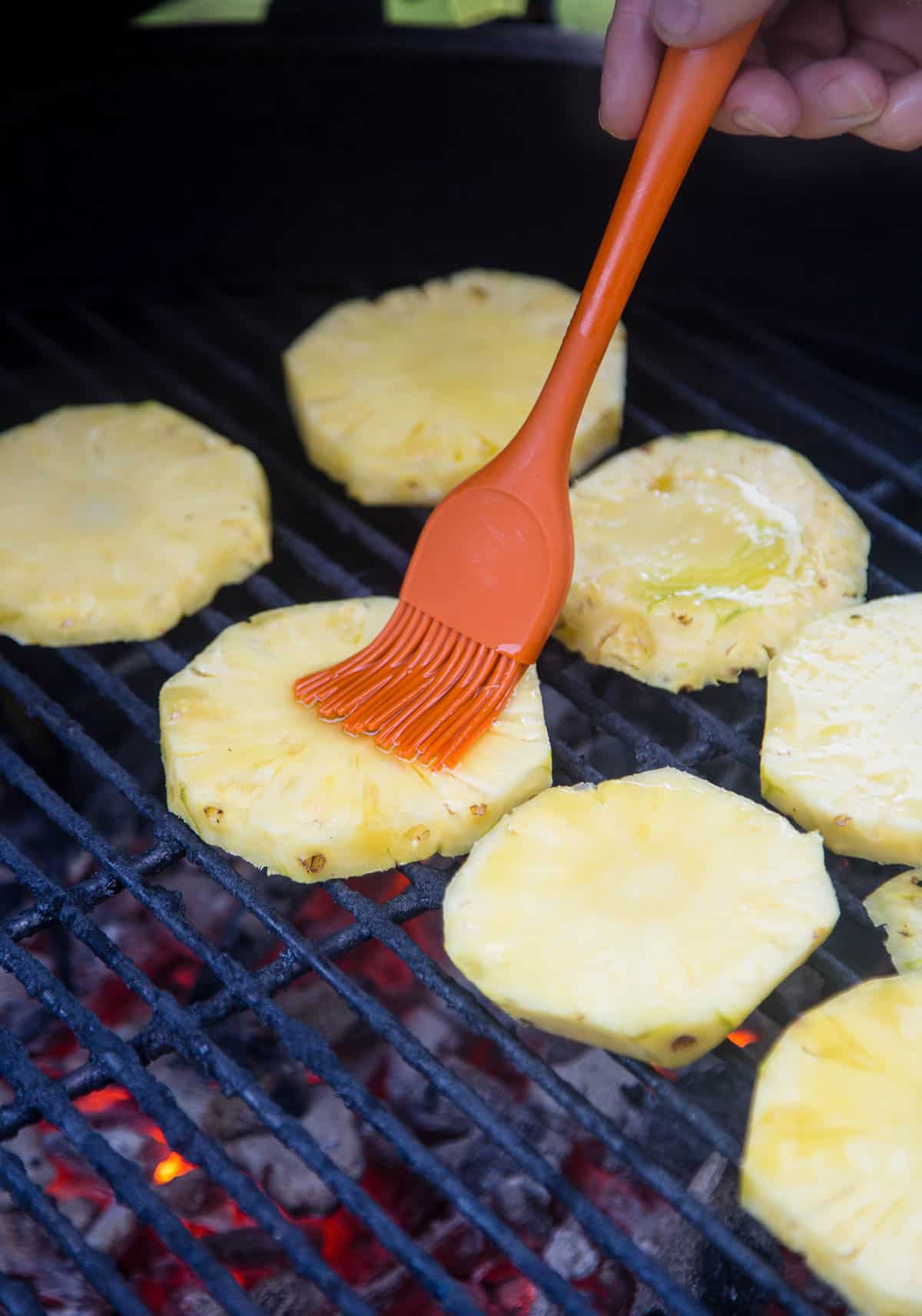 Grilling slices of pineapple on a charcoal grill