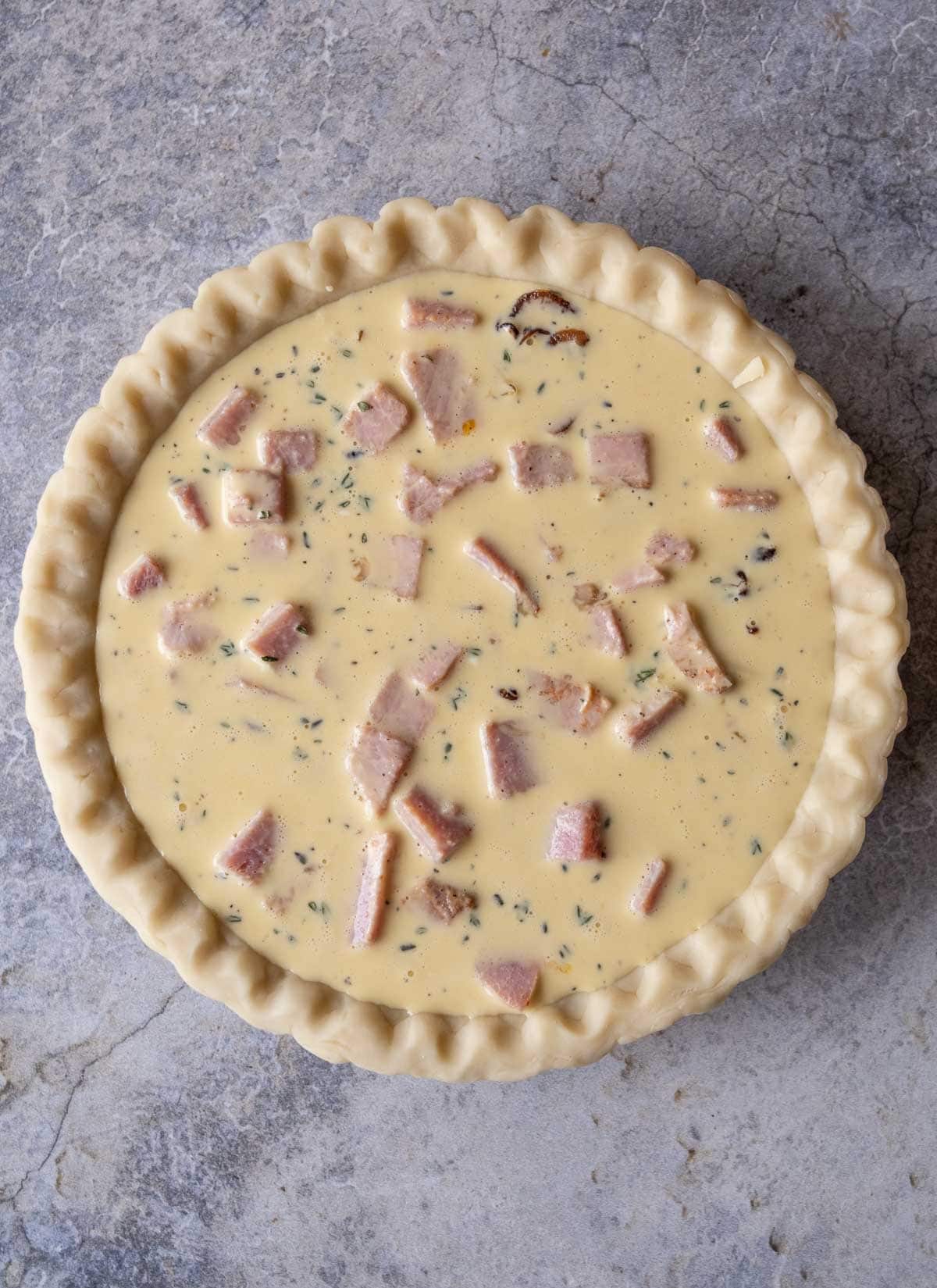 a ham quiche before baking in the grill