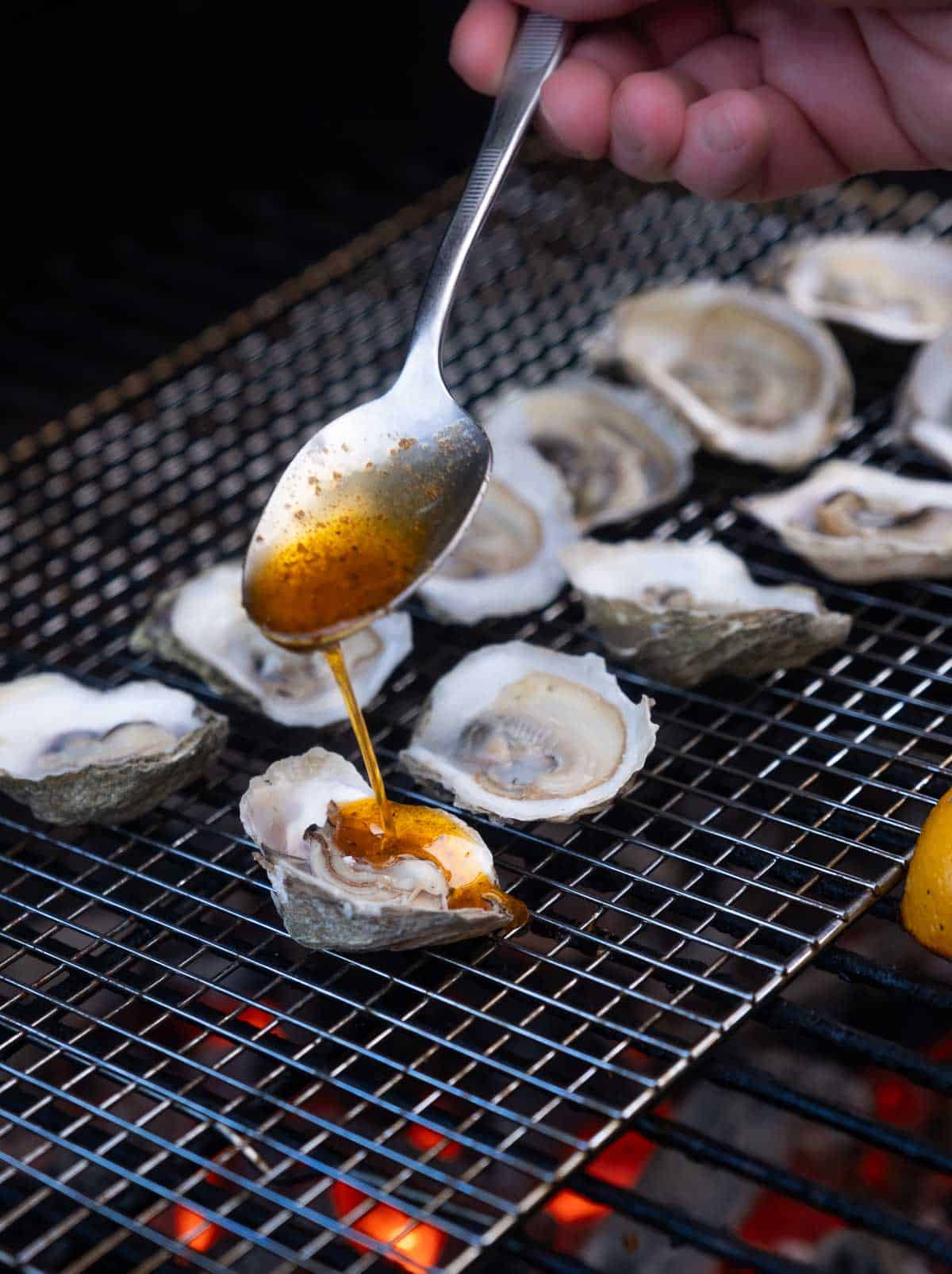 topping grilled oysters with melted butter